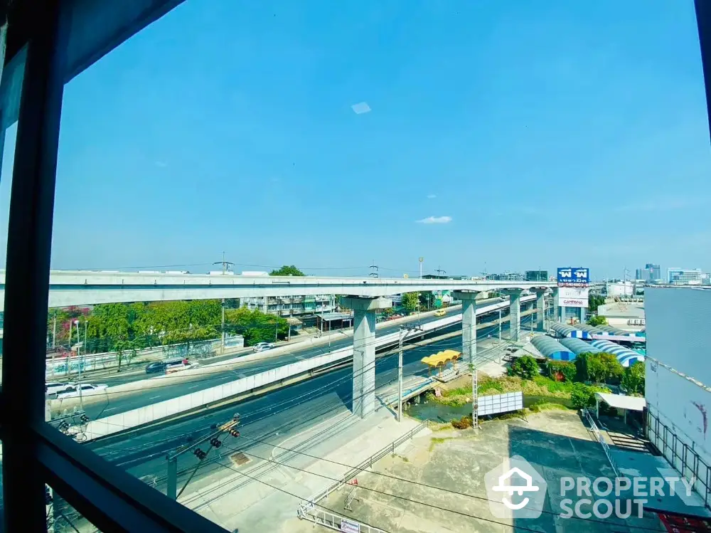 Stunning urban view from high-rise window showcasing elevated highways and cityscape.