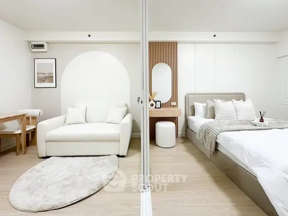 Modern studio apartment with stylish living and bedroom areas, featuring minimalist decor and neutral tones.