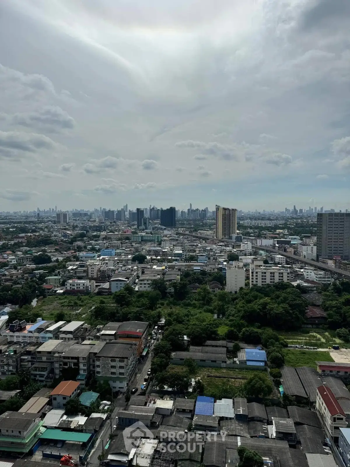 Stunning cityscape view from high-rise building showcasing urban skyline and greenery.