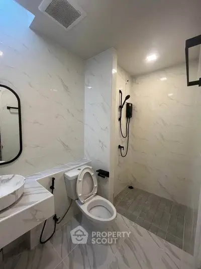 Modern bathroom with sleek design, featuring a shower and elegant fixtures.