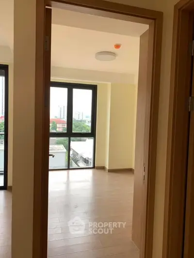 Spacious apartment interior with large windows and wooden flooring, offering a bright and airy atmosphere.