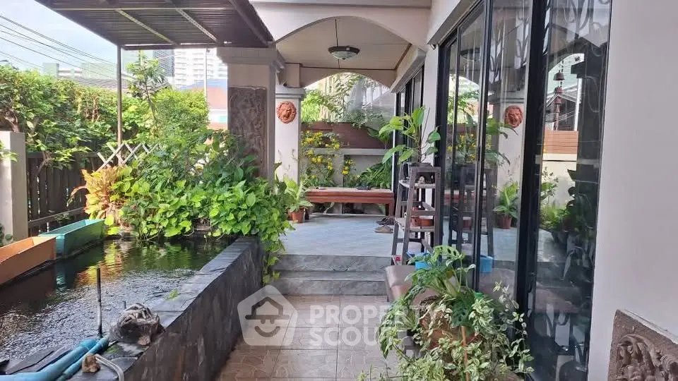 Charming garden patio with lush greenery and serene water feature, perfect for relaxation and outdoor enjoyment.