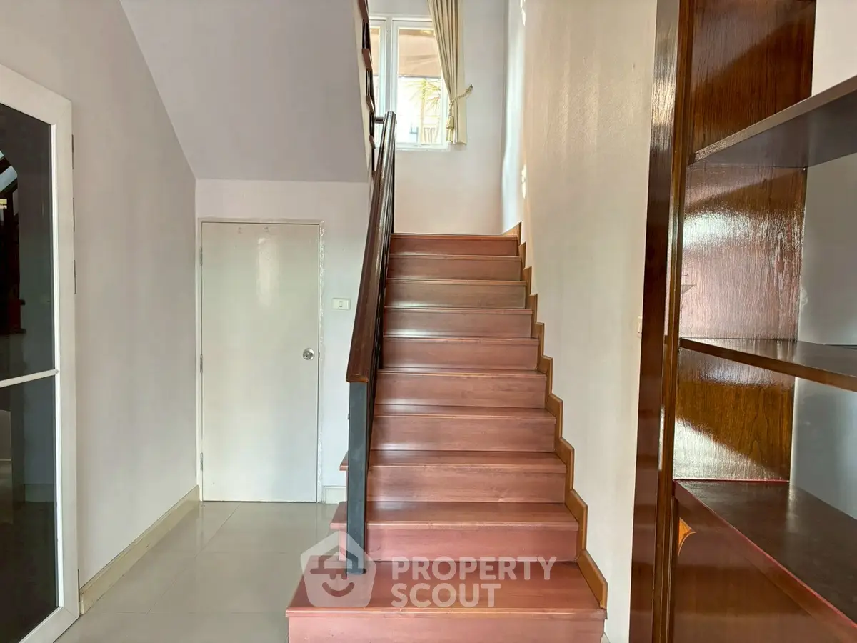 Spacious interior staircase with wooden steps and natural light, perfect for modern homes.