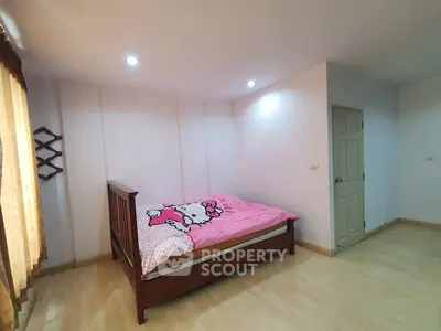Spacious bedroom with wooden bed and bright decor, ideal for cozy living.