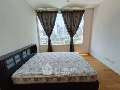 Spacious bedroom with city view and large window, featuring a comfortable bed and elegant curtains.