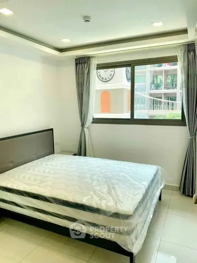 Bright and airy bedroom with large window and modern decor in a stylish apartment.