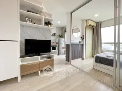 Modern studio apartment with open layout, featuring sleek furnishings and natural light.