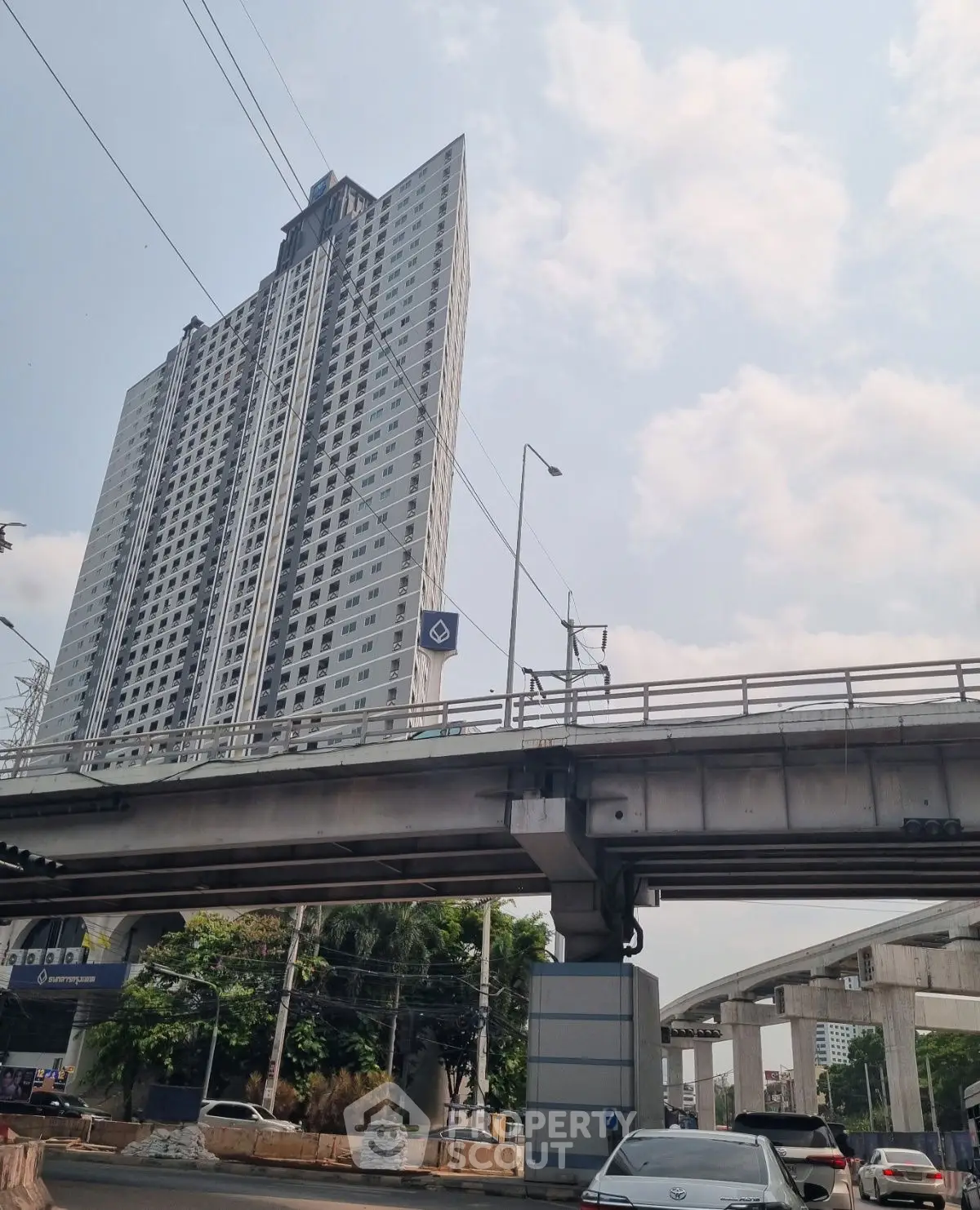 Modern high-rise building with urban infrastructure and clear sky view.