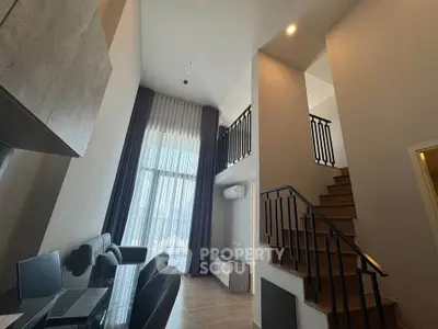 Modern duplex apartment with high ceilings and stylish staircase