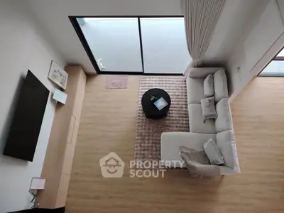 Modern living room with sleek furniture and large window for natural light.