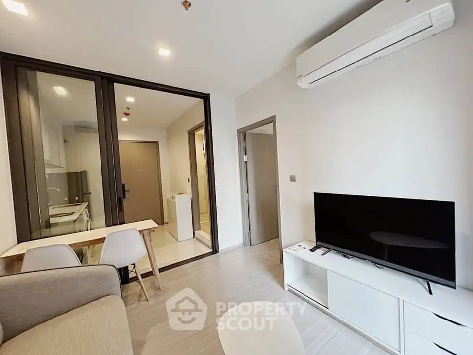 Modern living room with sleek furniture and open kitchen layout in a stylish apartment.