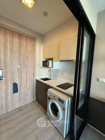 Compact modern kitchen with washing machine and sleek cabinetry