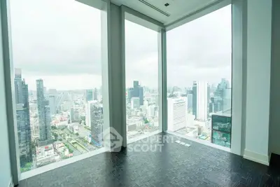 Stunning high-rise city view from modern apartment with floor-to-ceiling windows.