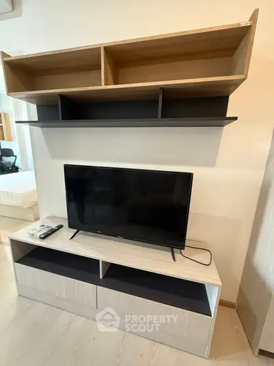 Modern living room with sleek TV stand and wall-mounted shelves, perfect for stylish urban living.