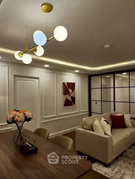 Elegant living room with modern chandelier, cozy sofa, and stylish decor in a contemporary apartment.