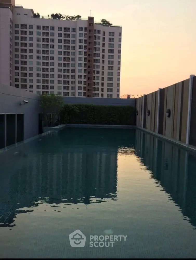 Stunning rooftop pool with cityscape view at sunset, perfect for relaxation and leisure.