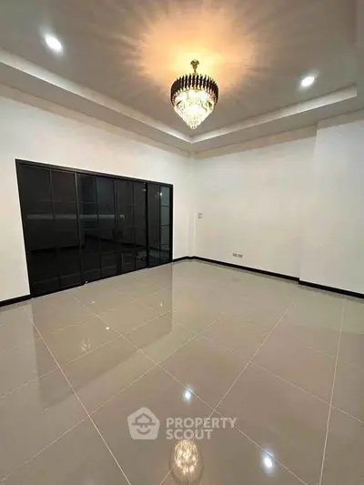 Spacious modern living room with elegant chandelier and glossy tiled floor