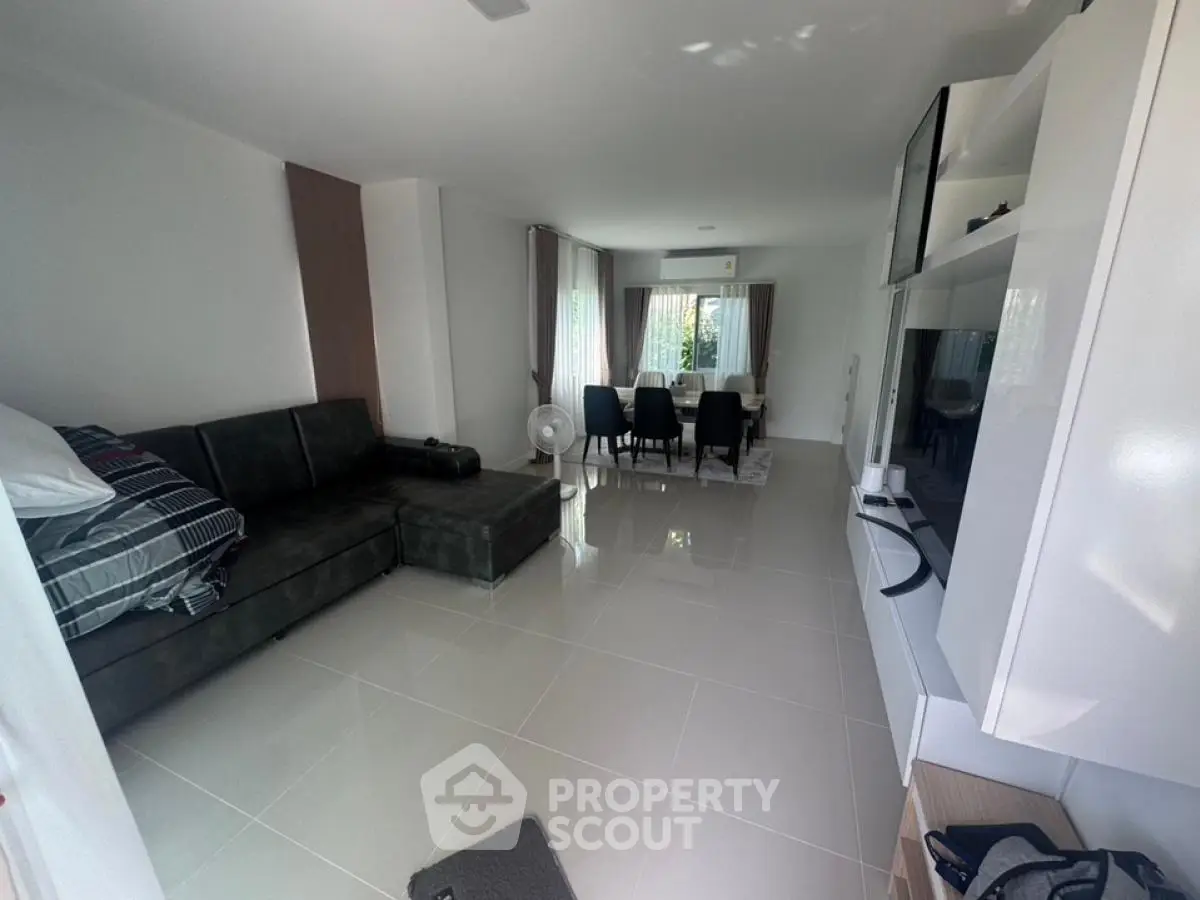 Spacious modern living room with sleek furniture and dining area, perfect for family gatherings.
