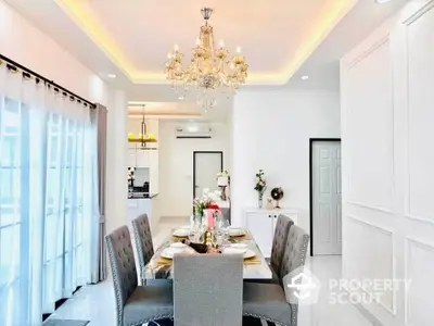 Elegant dining room with chandelier and modern decor in a bright, spacious home.