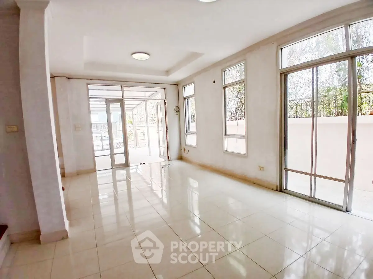 Spacious sunlit room with large windows and tiled flooring, perfect for modern living.