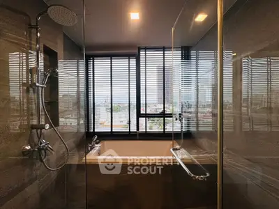 Luxurious bathroom with city view, featuring a modern shower and bathtub in a high-rise apartment.