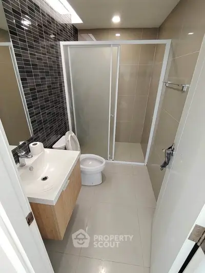 Modern bathroom with sleek design, featuring a glass shower and stylish vanity.