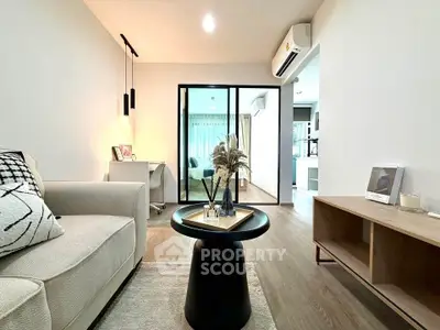Modern living room with stylish decor and sliding glass doors leading to a bright bedroom.
