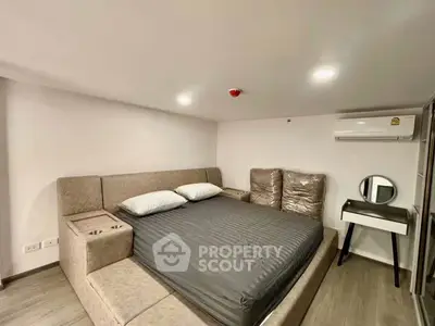 Modern bedroom with stylish bed and compact vanity in cozy apartment.