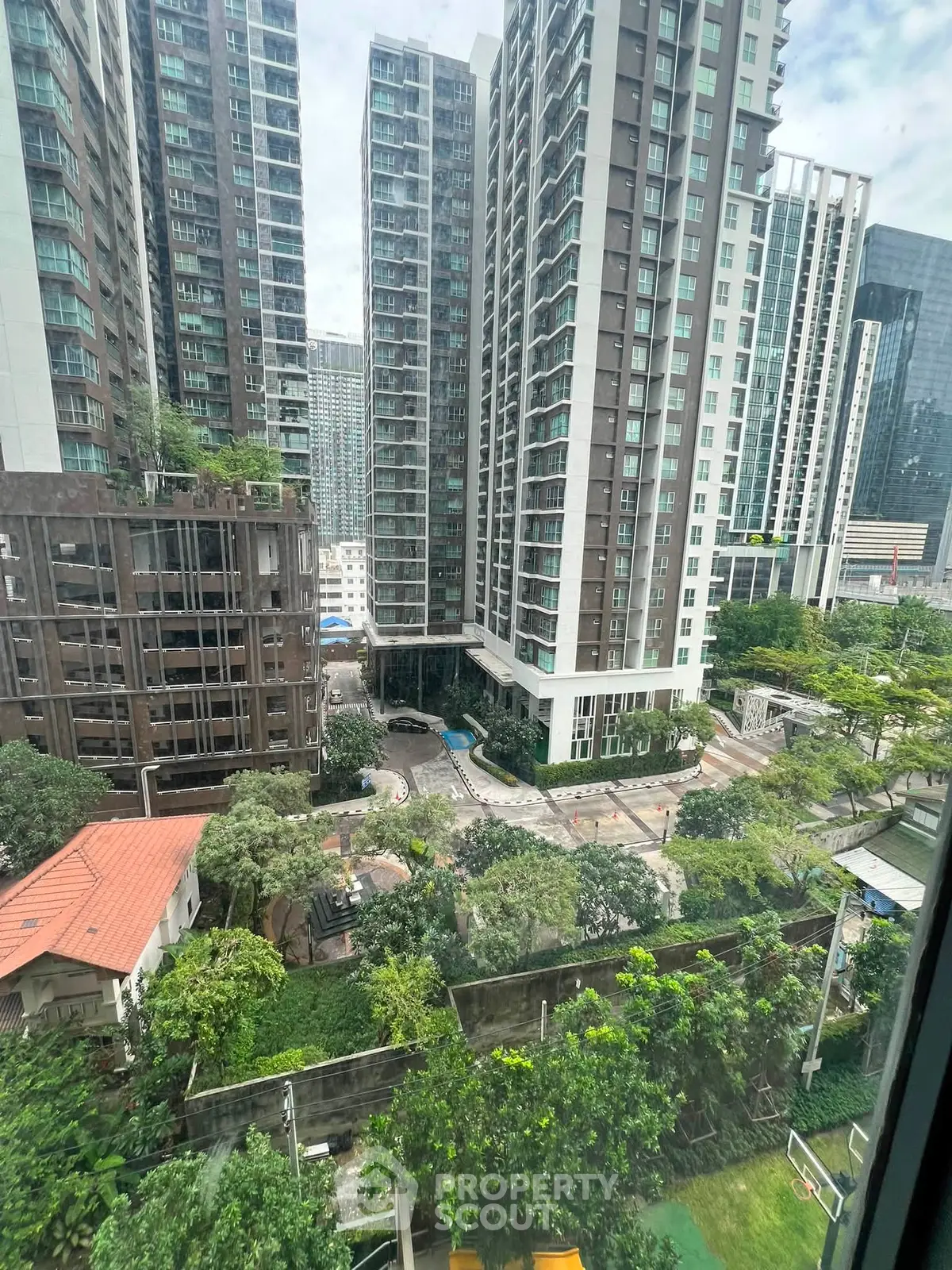 Stunning high-rise apartment view with lush greenery and modern architecture in a vibrant urban setting.