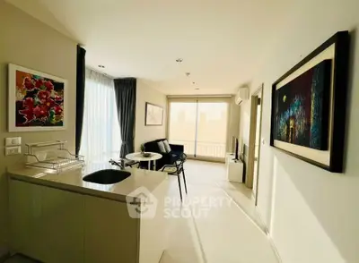 Modern living room with open kitchen, bright natural light, and stylish decor in a high-rise apartment.
