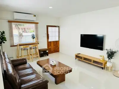 Modern living room with sleek furniture and wall-mounted TV, perfect for relaxation.