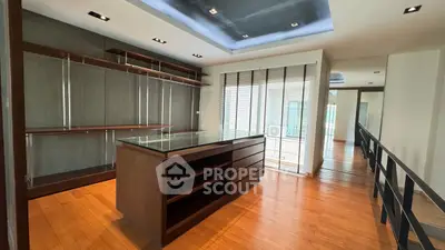 Spacious modern interior with wooden flooring and built-in shelving, ideal for a stylish home office.