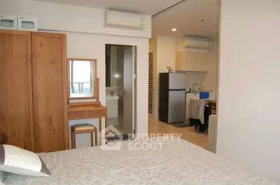 Cozy studio apartment with modern furnishings and compact kitchen area, ideal for urban living.