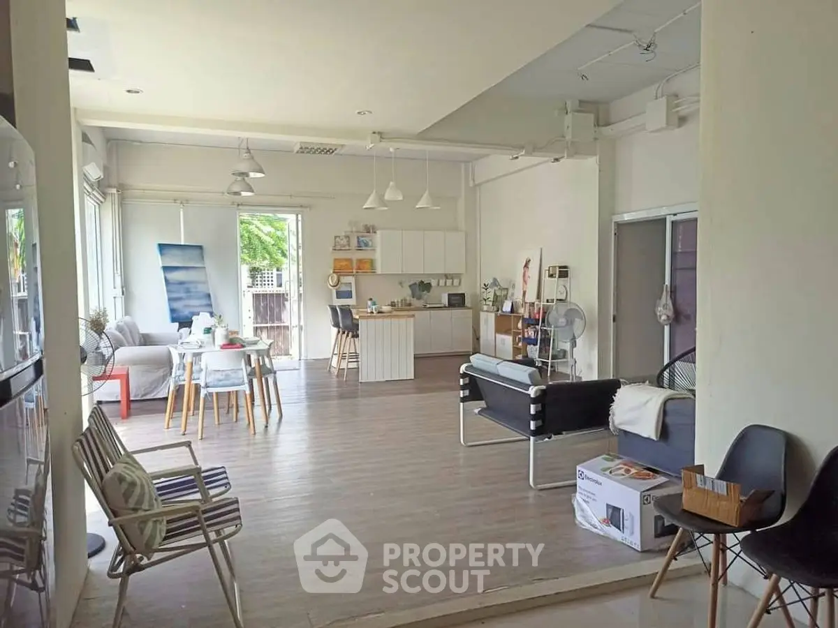 Spacious open-layout living area with modern kitchen and natural light.