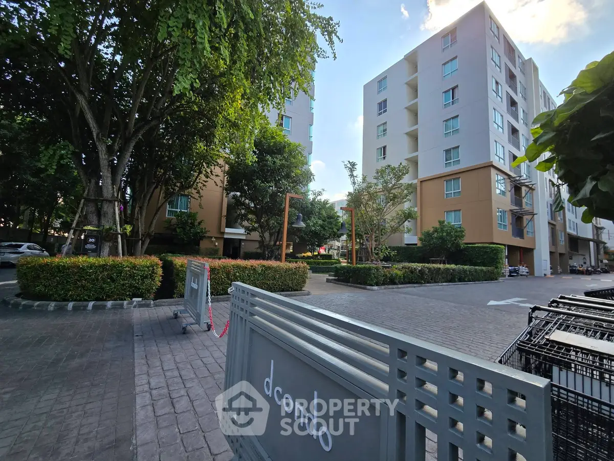 Modern condominium complex with lush greenery and spacious outdoor area