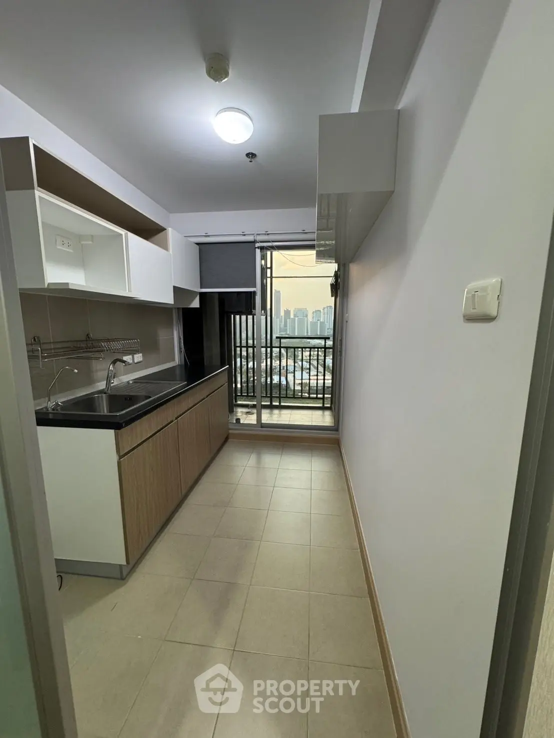 Modern kitchen with sleek cabinetry and city view balcony access.