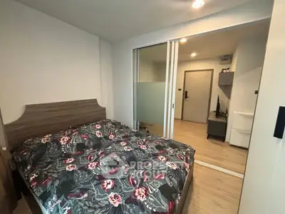 Cozy bedroom with floral bedding and sliding glass doors in modern apartment.