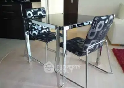 Modern dining area with sleek black table and stylish patterned chairs in a contemporary apartment.