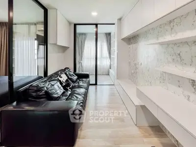 Modern living room with sleek black leather sofa and marble accent wall