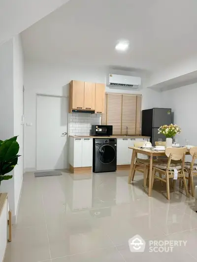 Modern kitchen with dining area, featuring sleek appliances and stylish decor.