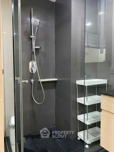 Modern bathroom with sleek shower and storage shelves in a contemporary home.