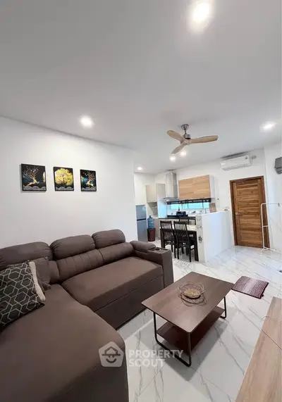 Modern open-layout living room with stylish kitchen and cozy seating area.