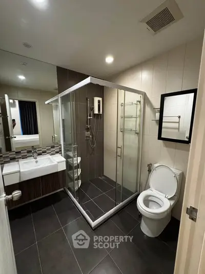 Modern bathroom with glass shower enclosure and sleek fixtures