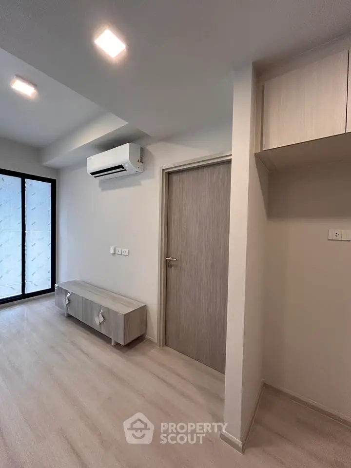 Modern minimalist living room with sleek air conditioning and stylish wooden flooring.