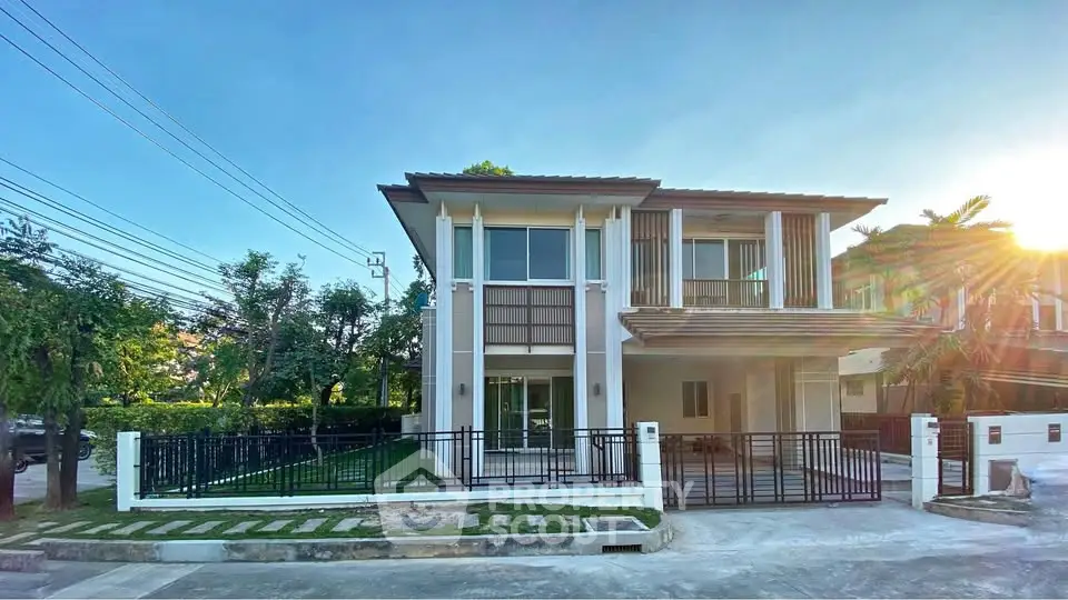 Modern two-story house with large windows and a spacious front yard in a serene neighborhood.