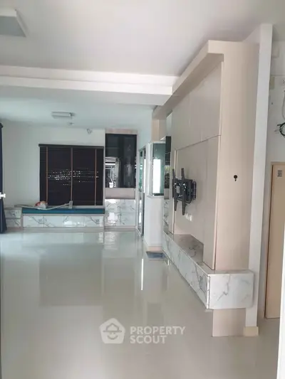Spacious modern living room with sleek marble accents and large windows for natural light.