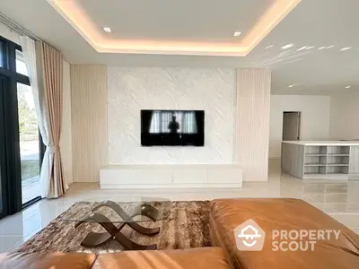 Spacious living room with modern design, elegant marble wall with mounted TV, plush leather sofa, and open kitchen layout.