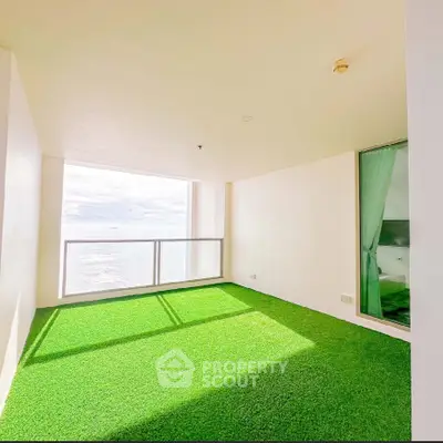 Stunning ocean view from a spacious balcony with artificial grass flooring, perfect for relaxation.