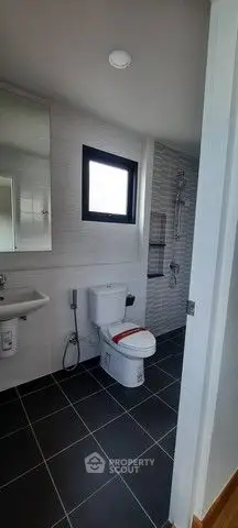 Modern bathroom with sleek fixtures and tiled flooring in a contemporary home.