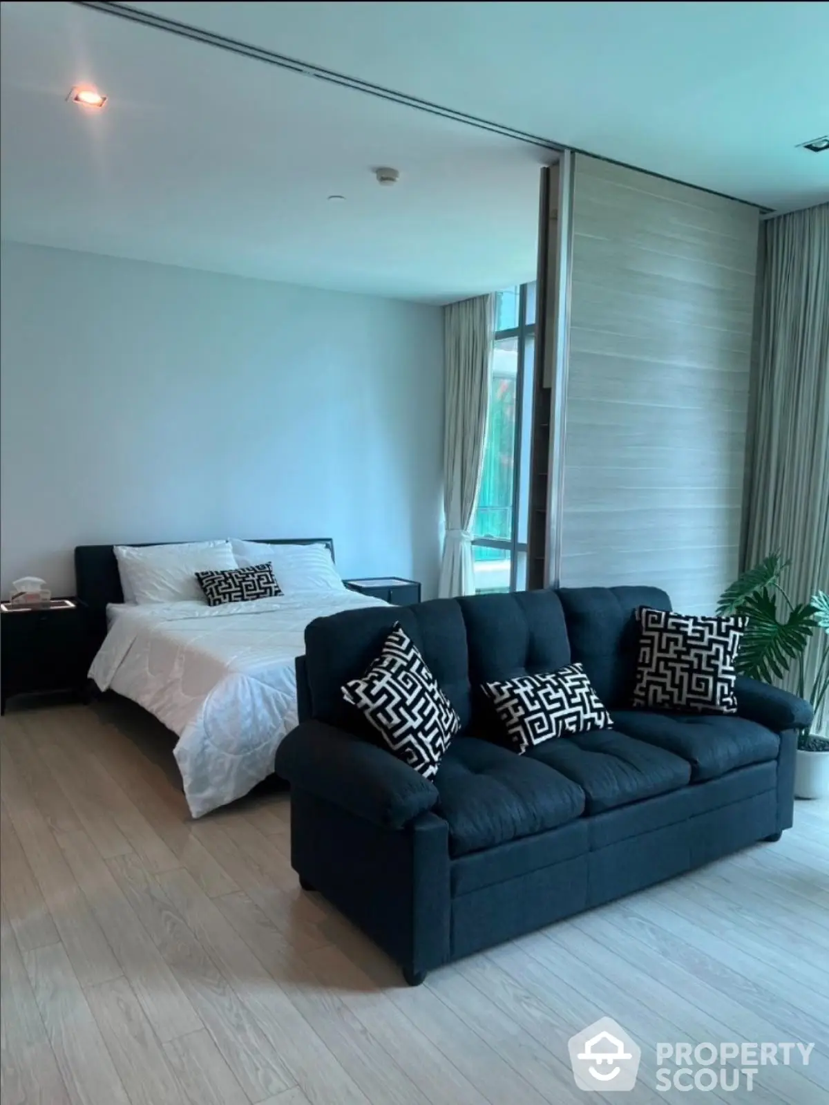 Spacious bedroom with modern decor and comfortable seating area